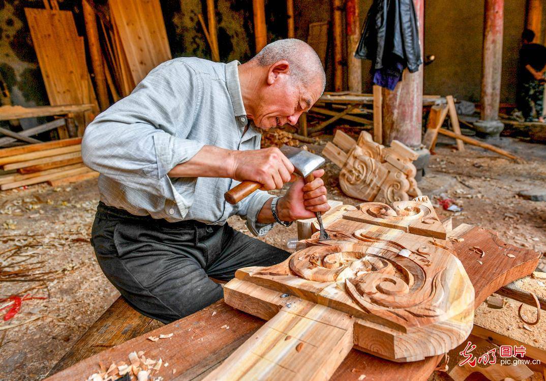 2021年4月1日,木雕师傅用传统技艺雕刻古民居的蝴蝶头