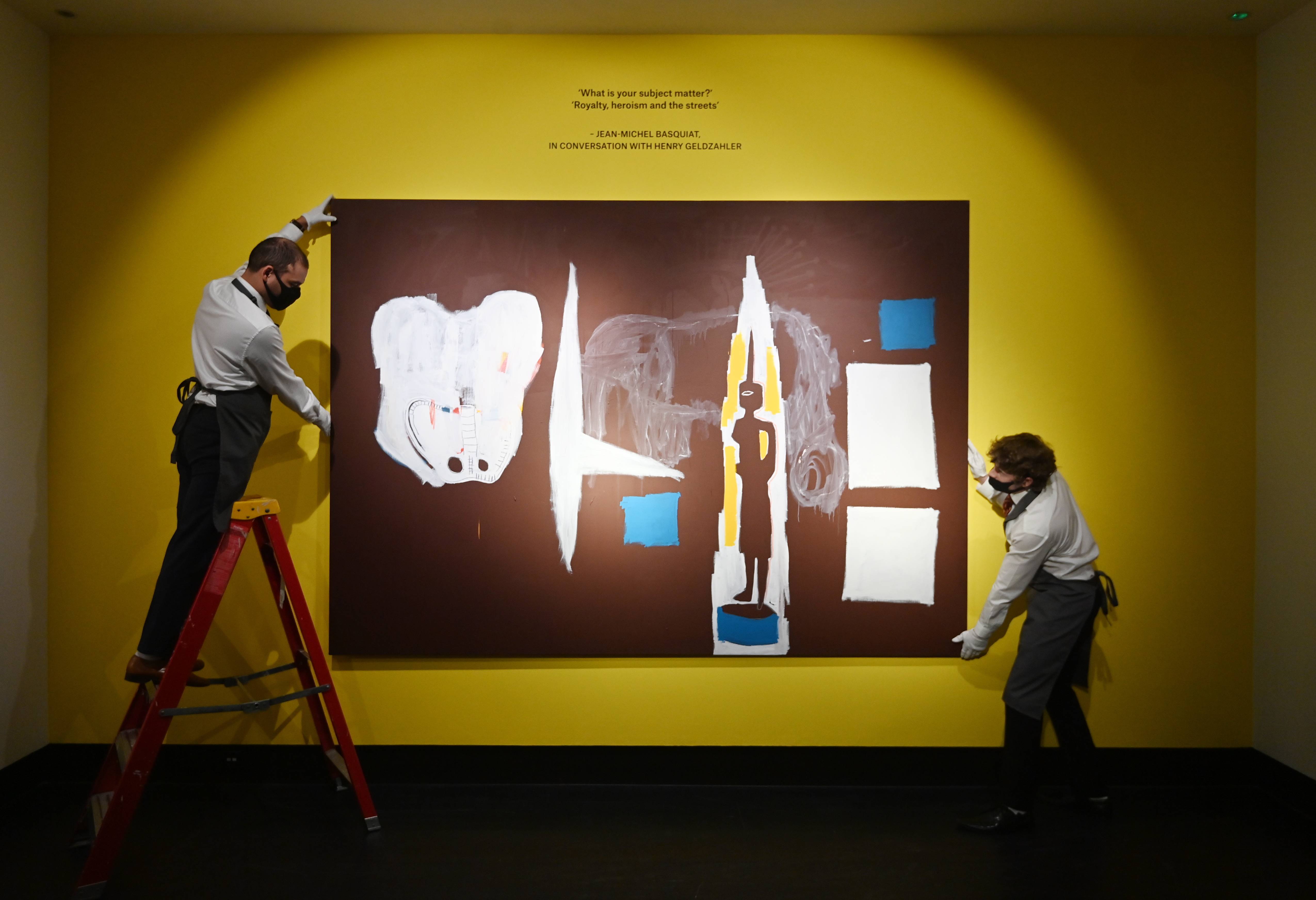 摆放一副美国艺术家巴斯奎特的画作,为重新开放后举办的画展做准备