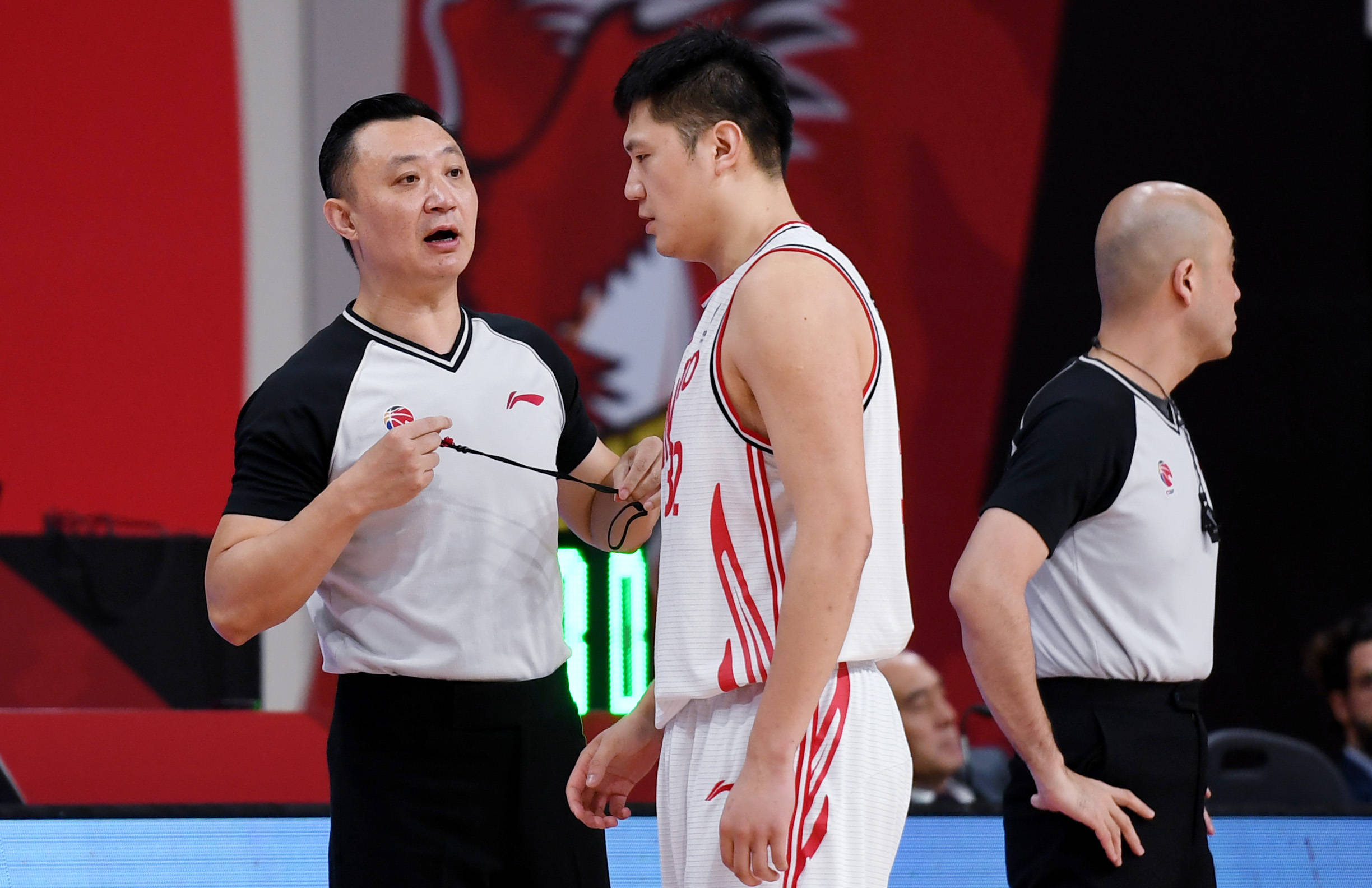 4月13日,主裁判闫军(左)与青岛每日优鲜队球员王庆明交流.