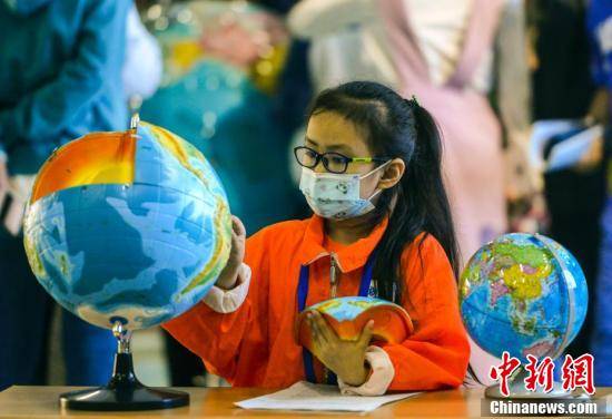 学生通过地球仪了解地球内部结构.