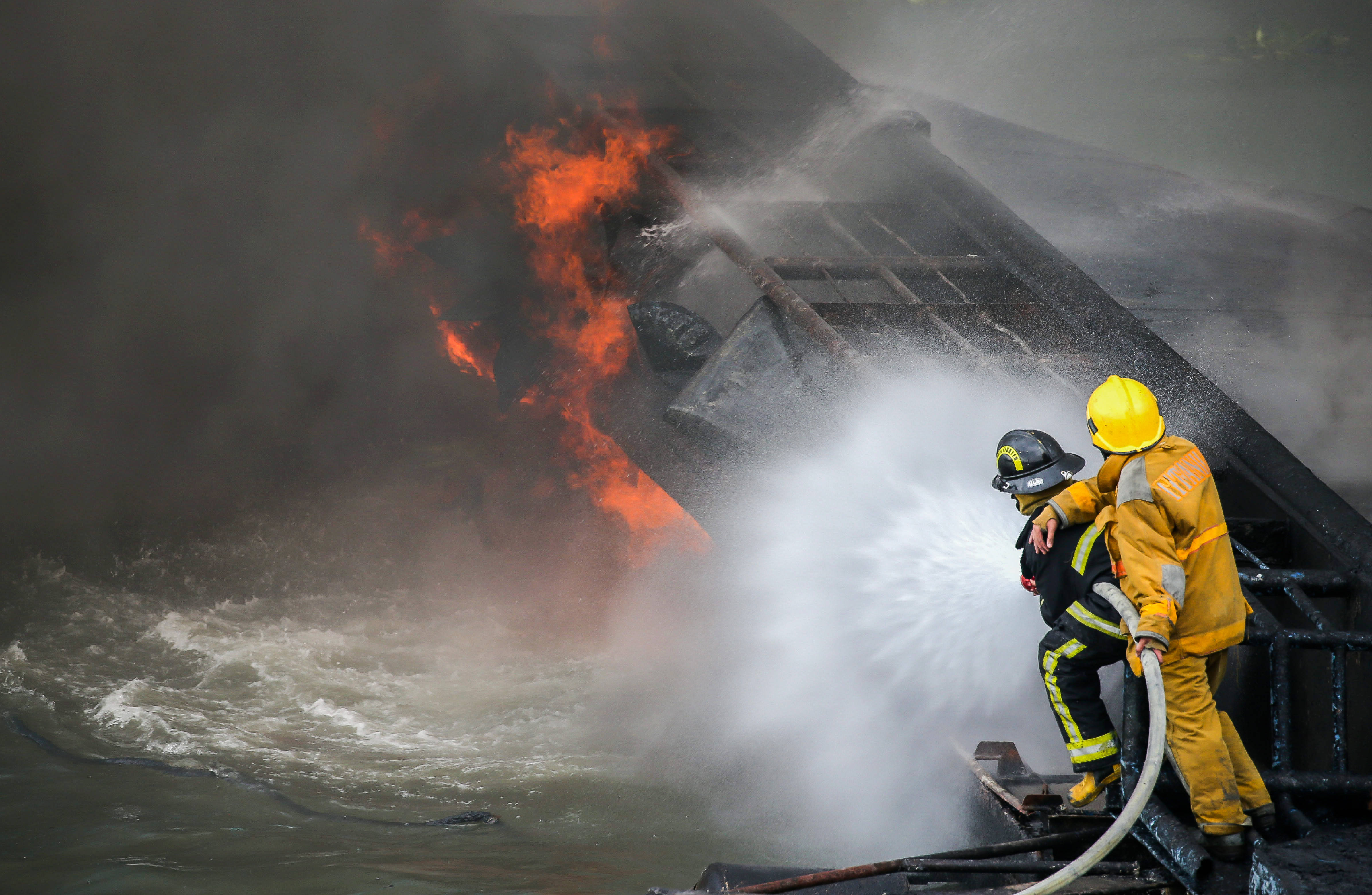 6月12日,消防人员在菲律宾马尼拉发生火灾的码头灭火.