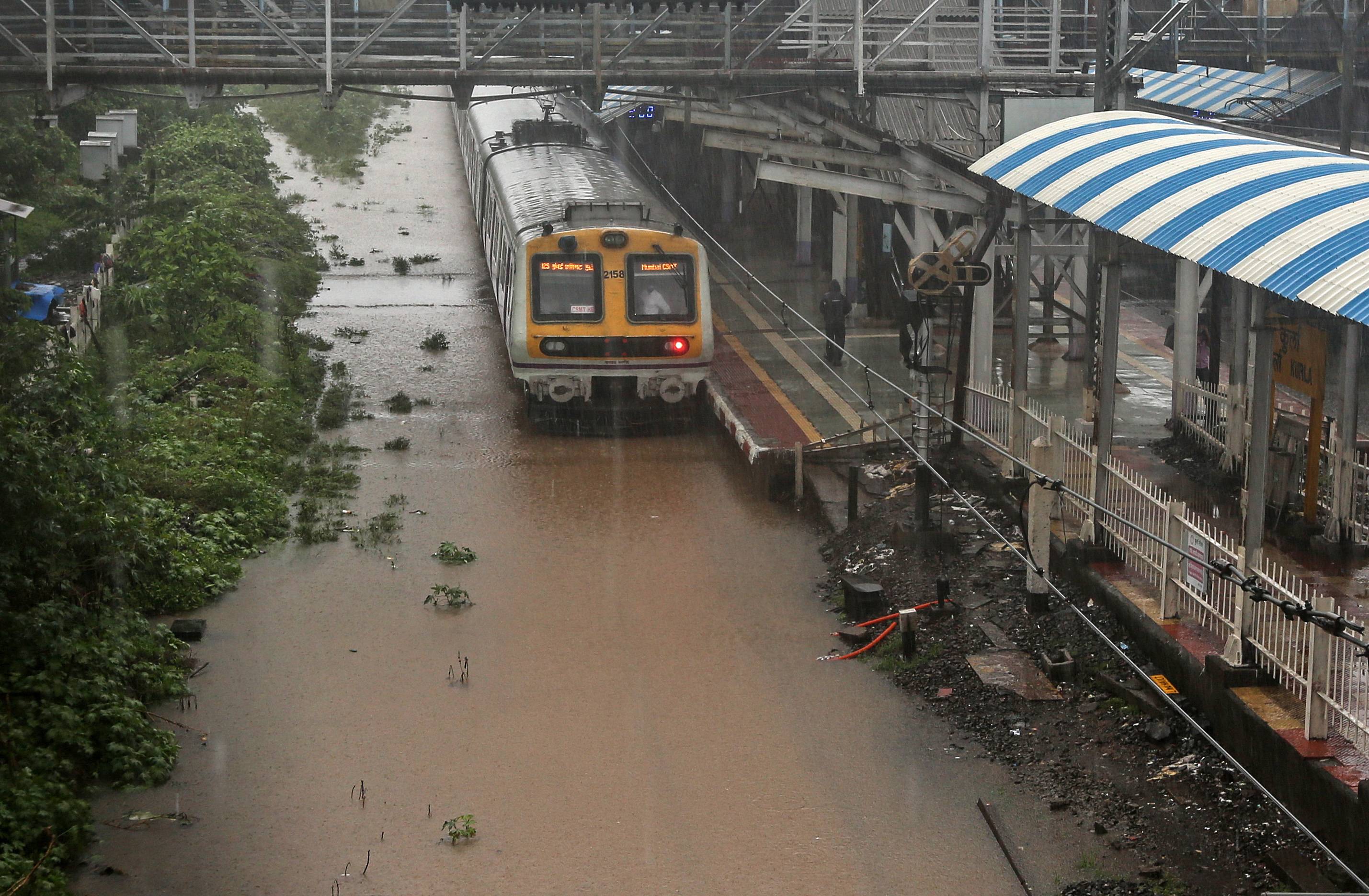 6月9日,在印度孟买,一辆火车在大雨中行驶