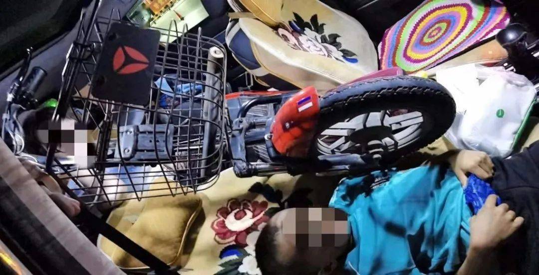 盐池收费站一男子将电动车塞进小轿车里电动车轮下还坐着熟睡的孩子