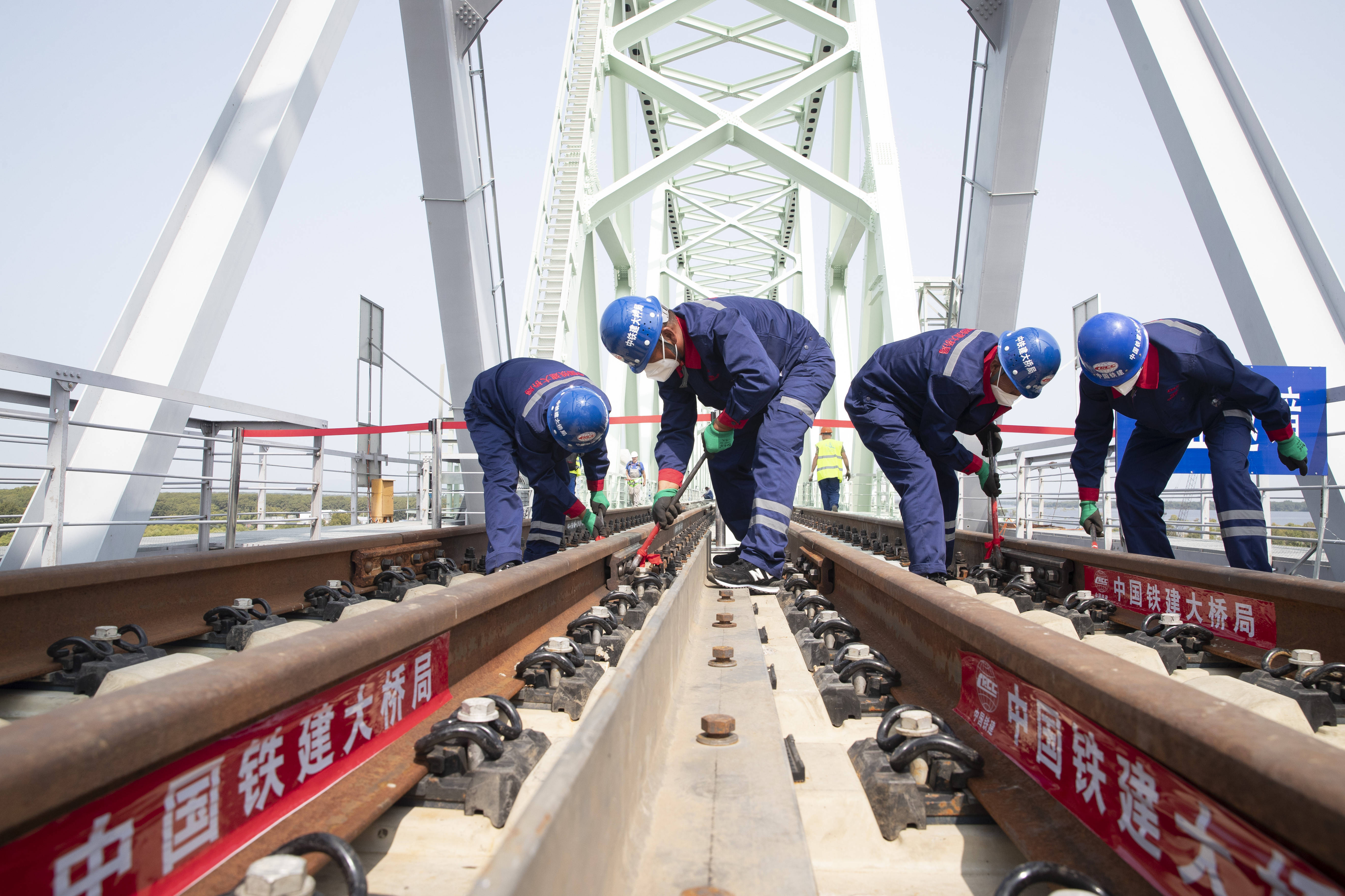 8月17日,工人在同江中俄黑龙江铁路大桥施工现场进行轨道夹板安装