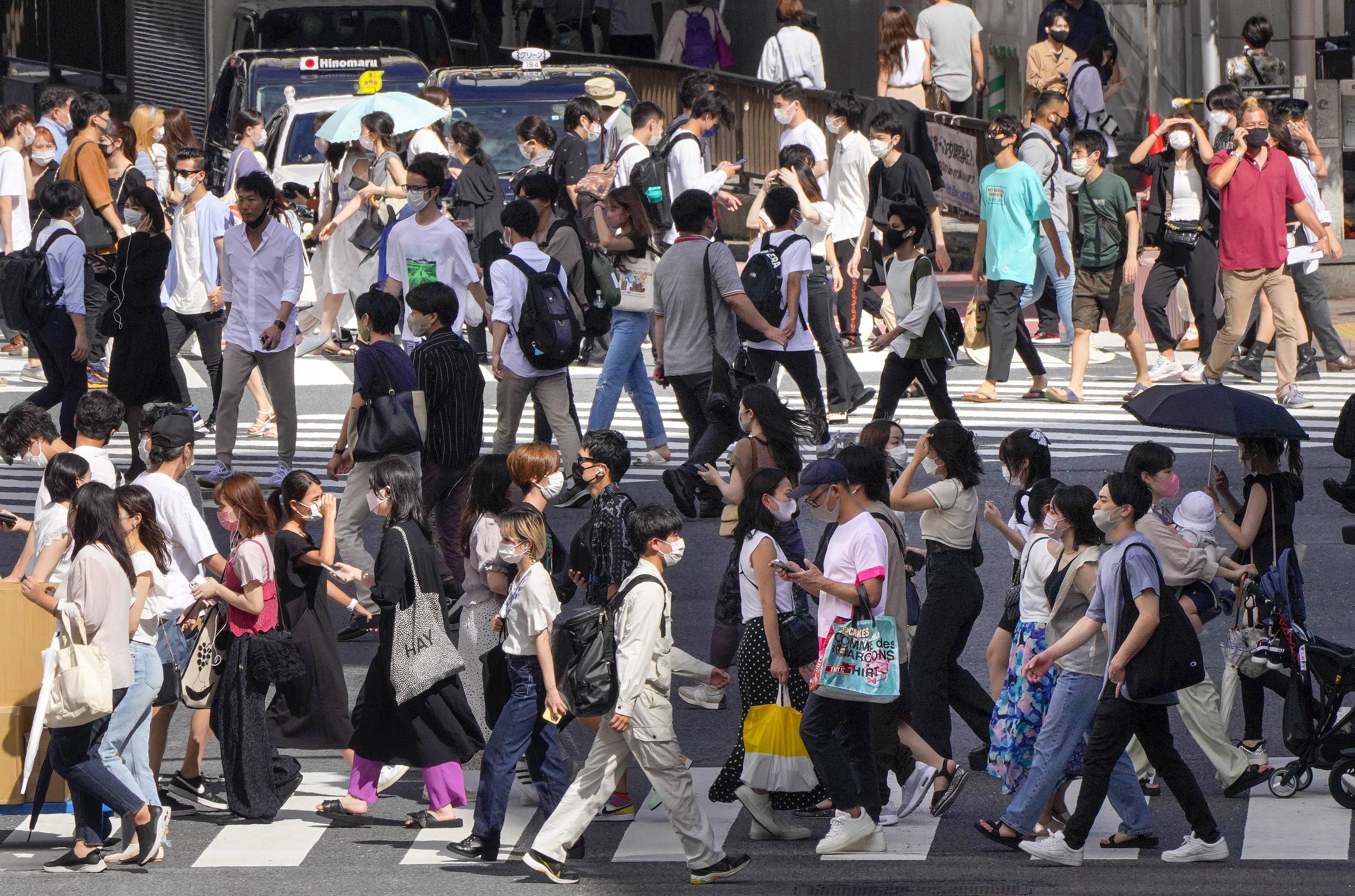 这是8月18日在日本东京街头拍摄的等待过马路的行人