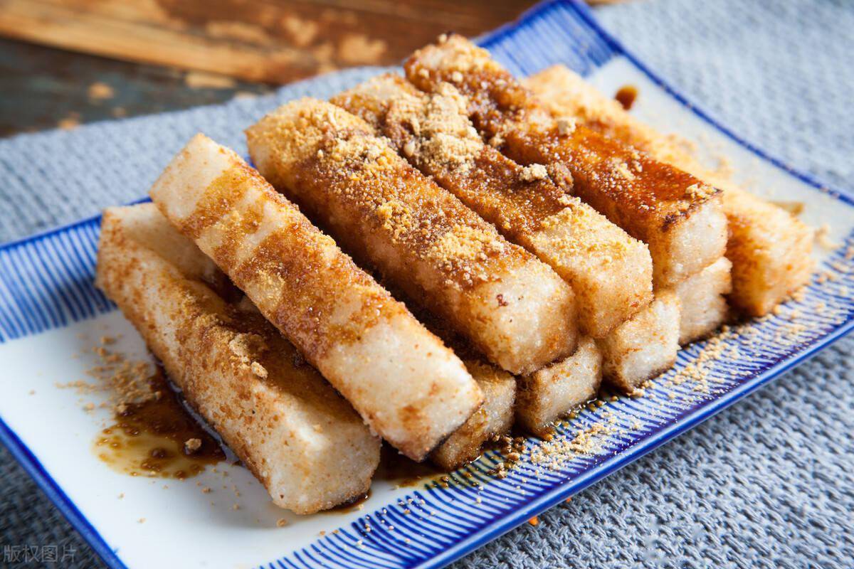 糍粑放入黄豆粉中滚一圈,均匀的包裹,然后在上面淋上熬好的红糖就可以