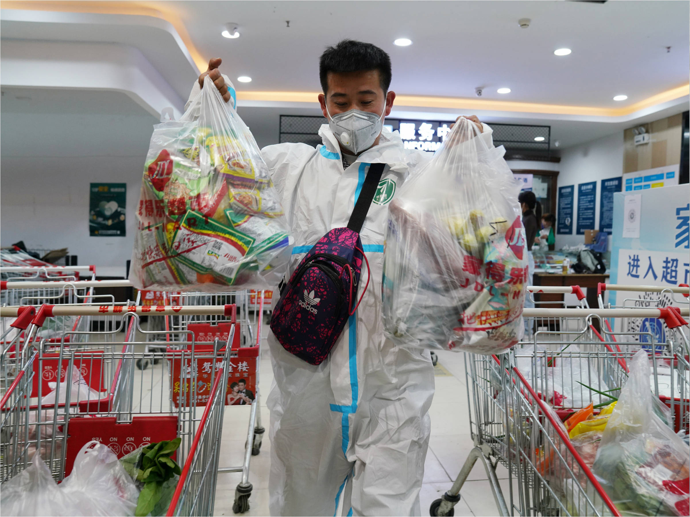 在巴彦县一超市门口,配送小哥李阳取走居民线上订购的生活物资准备
