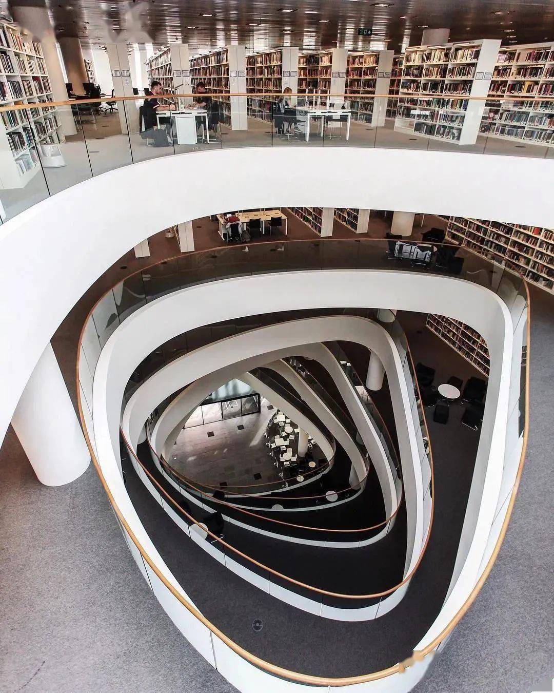 值得一提的是,lse图书馆中有一套别具一格的设计,螺旋楼梯环绕着一对