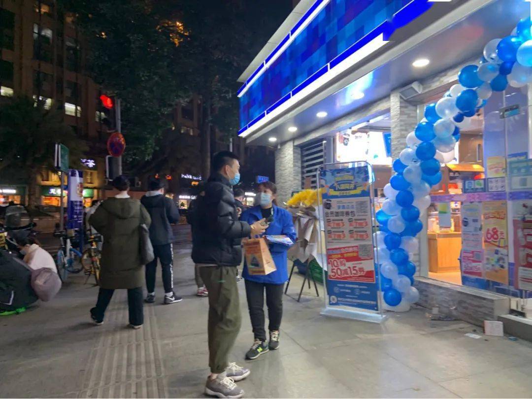 门口还有几位发传单的嬢嬢气球,花篮,活动海报但远看这家罗森好像已经