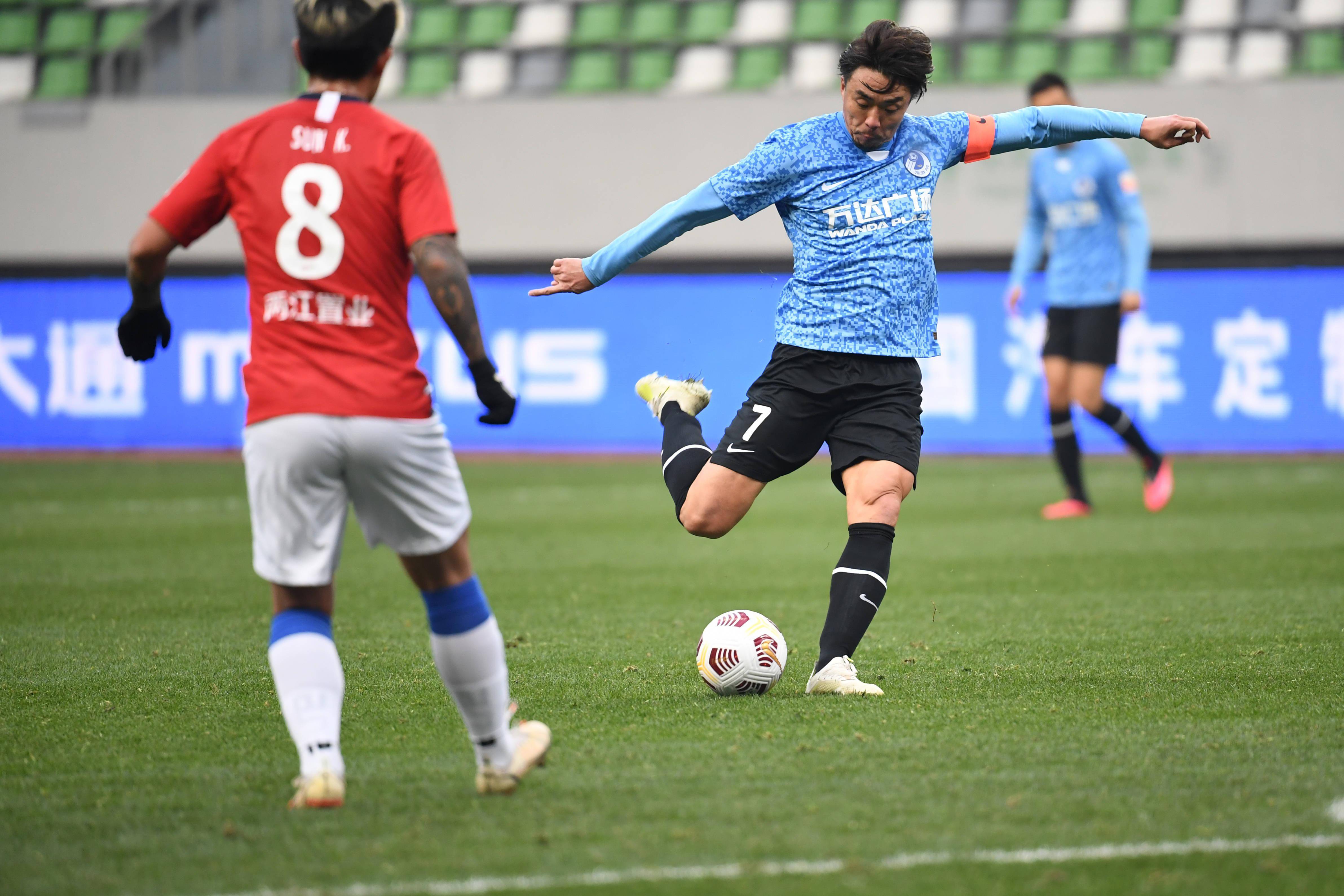 12月28日,大连人队球员赵旭日(右)在比赛中射门.