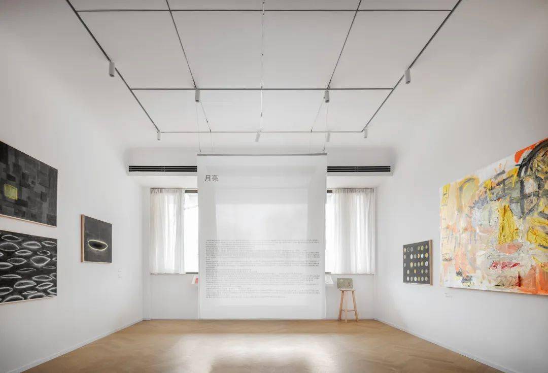 画廊展厅中,墙面与天花板仅以白色涂料简单粉饰,屋顶与墙面以弧形相连
