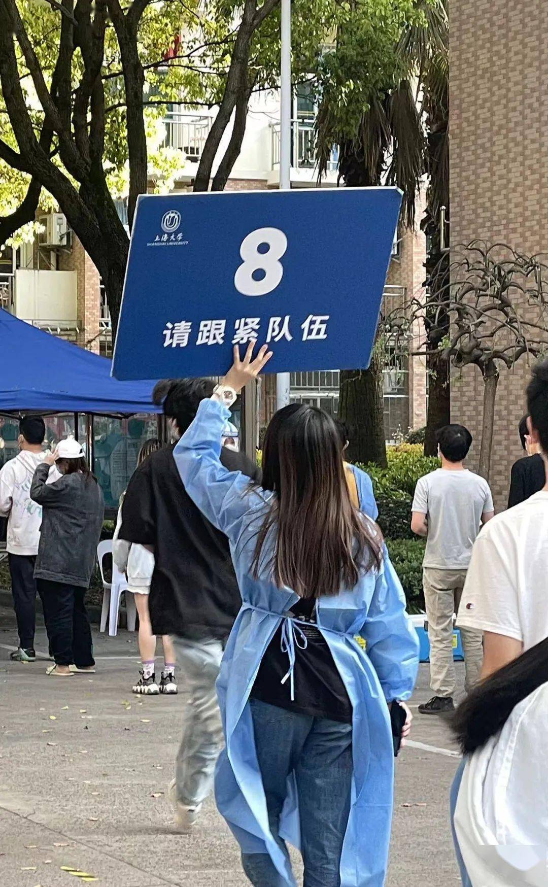 我帮助预约核酸检测的二维码,维持排队的秩序,举牌引导核酸队伍