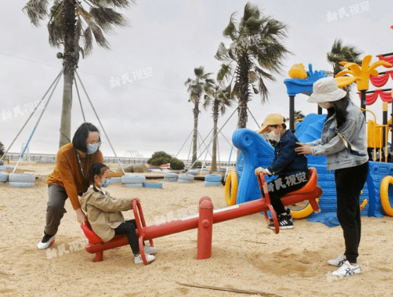 金山城市沙灘,家長帶著小朋友在沙灘上的兒童樂園玩耍新民晚報記者