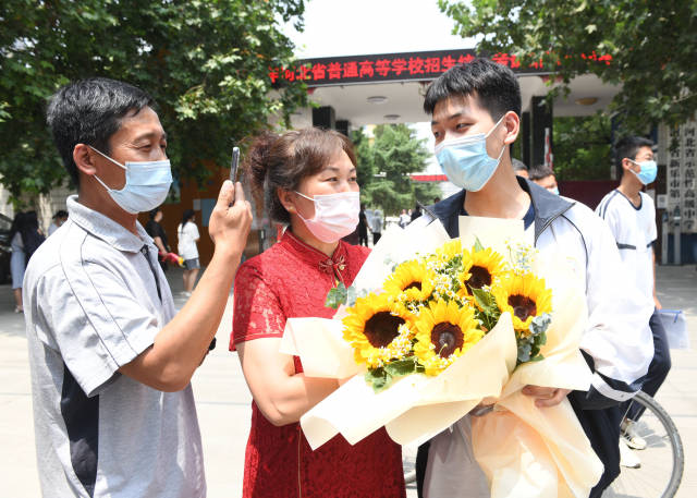 6月9日,在河北省石家庄新乐市一中考点,结束高考的学生和家长拍照留念