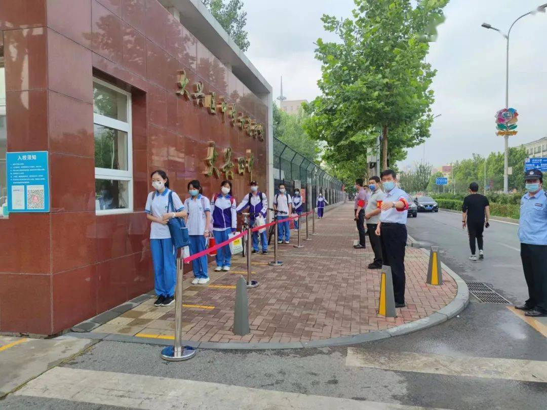 大兴四中,七中的同学们穿着整齐的校服,按校门口地面上的标识,自觉