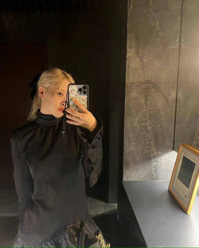 朴彩英拍照的背景板是灰色调的,很大气,她本人的的造型十分休闲,一头