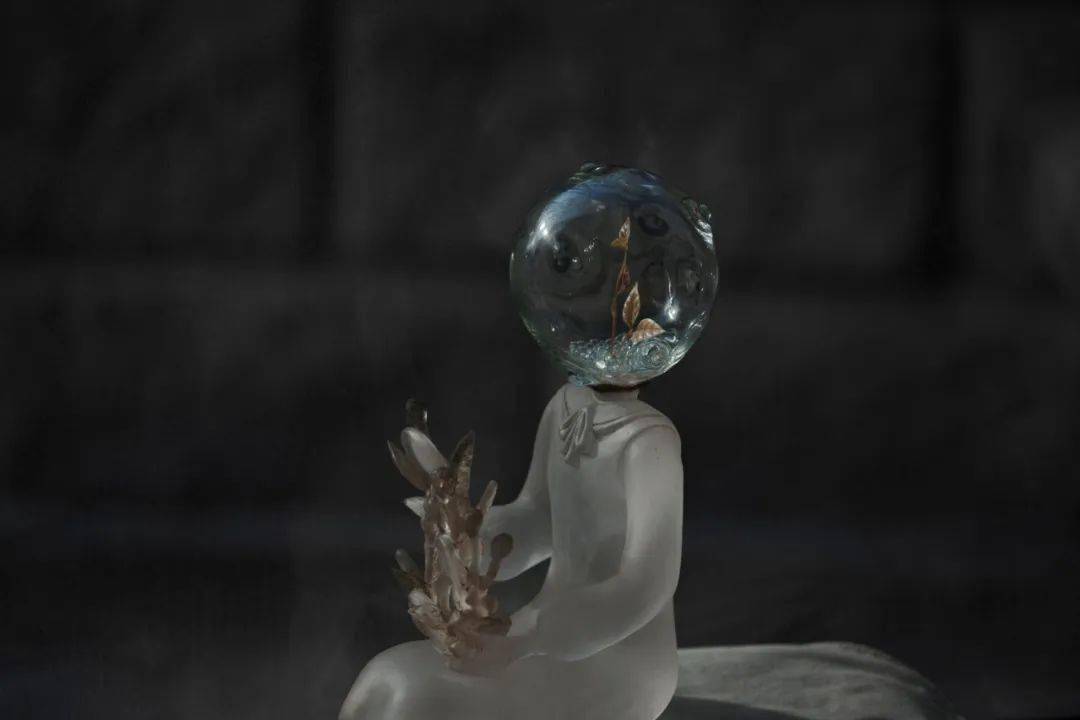 戴着尖帽安静读书的女孩,胸前有一片不经意生长出来的树叶,提醒在纷扰