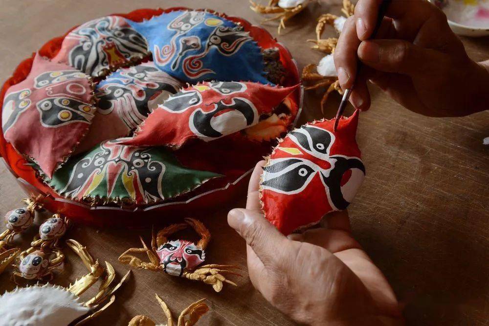 杜宝槐在创作蟹壳画.(受访者供图)碧水蓝天,海风轻拂.