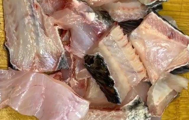 第2步:将黑鱼清洗干净,去头去骨头,鱼骨头切小块10ml料酒,姜片,蒜片和