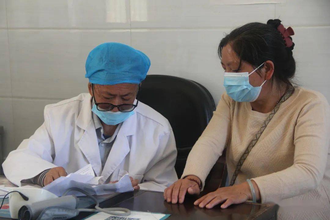 "坐在李学东医生旁边的大妈仔细的叙述着自己的症状,诊疗室门外还有不