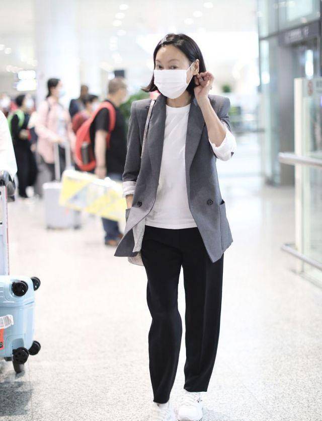 惠英红素颜走机场,西装打扮利落干练,但看一双手就知道老了!