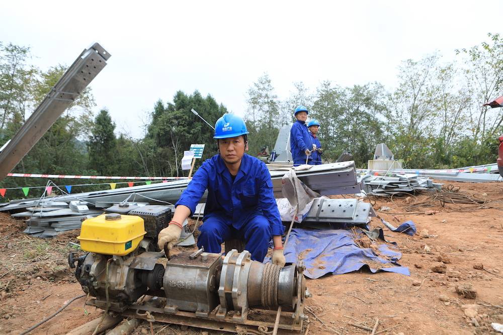 伴随着绞磨机的呼呼声,塔片等材料依次被运到塔上,做好安全措施的施工