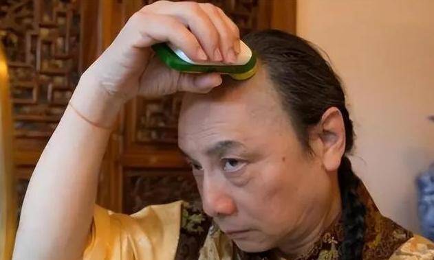 爱新觉罗·州迪留着长辫子,穿着黄色夹克,这是清朝的标志.