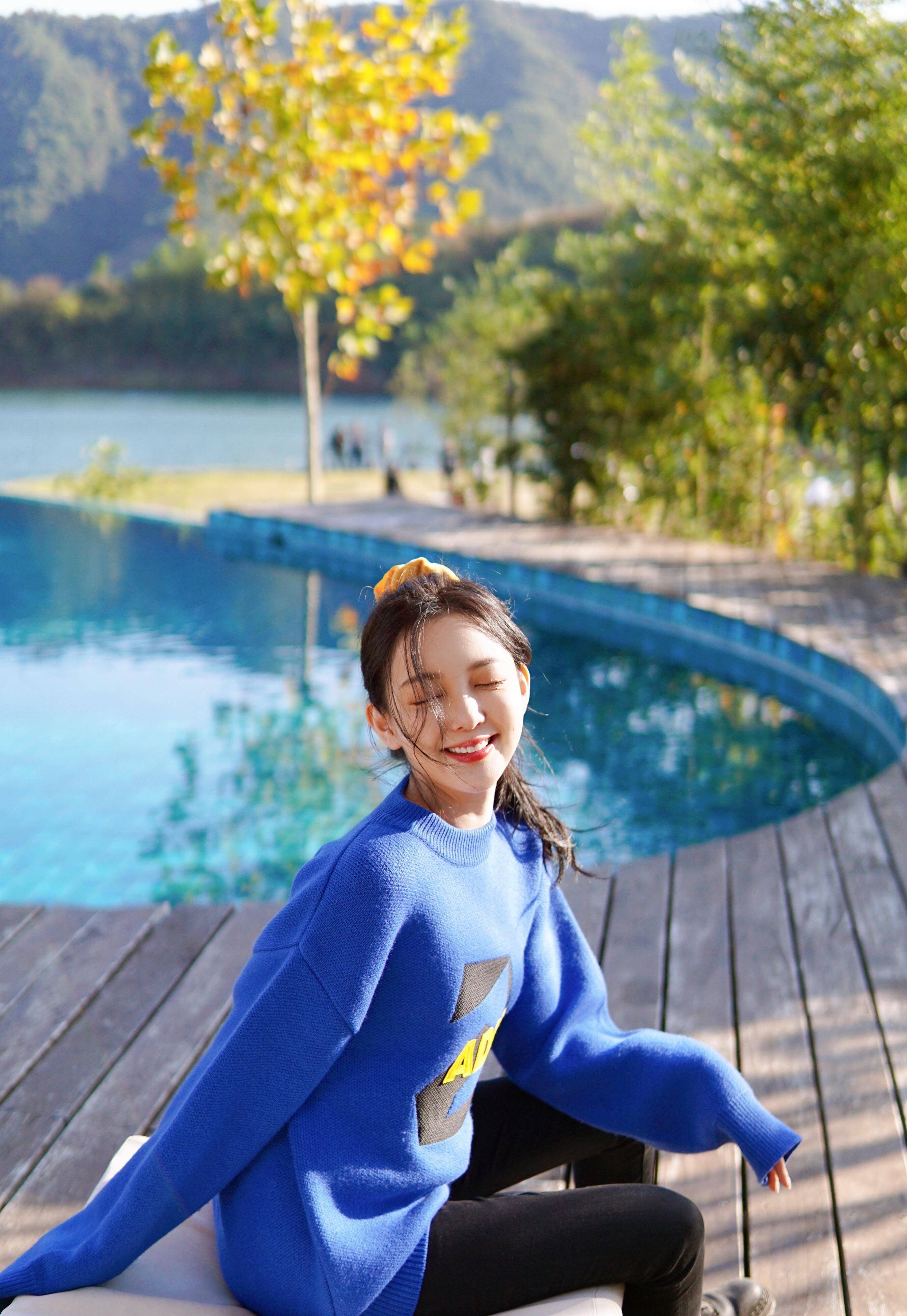 照片中的汪小敏,身穿一件宝蓝色毛衣,宝蓝色的毛衣相对于黑色白色可能