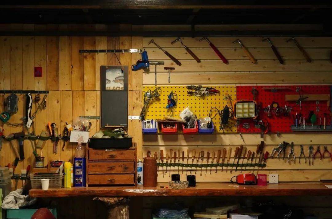 背景墙上大胆明亮的色彩置物板,各式各样的专业工具排放整齐有序.