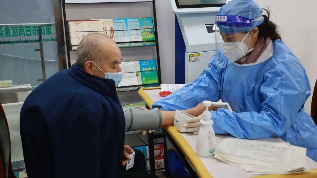 "在鱼洞下河码头处的区中医院新冠病毒疫苗接种点,预检医生正在为前来
