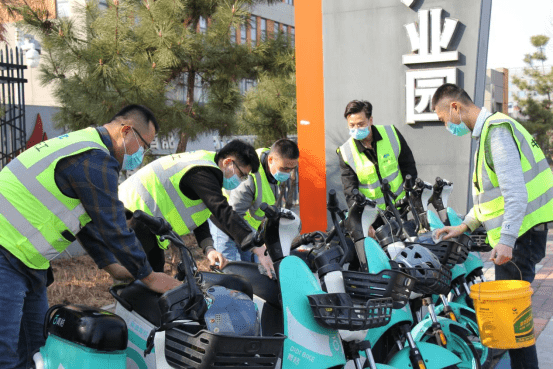沿着黄山路向湖南路方向,对摆放在路边的共享单车进行擦拭,清理与摆放