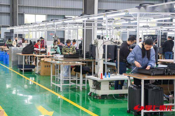 工业园湖南享同实业有限公司生产车间内,工人们正在进行箱包配件生产