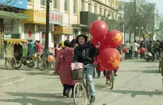 中心街买了气球回家过年的女孩乡间乐器班子正在演奏民间演出团体正在