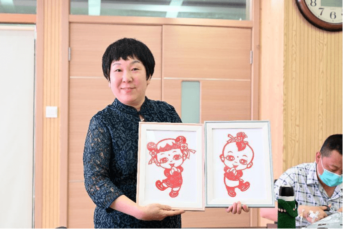 后,又手把手教大家剪出"妈妈的怀抱"的形象图案,祝福每位患者都能如愿