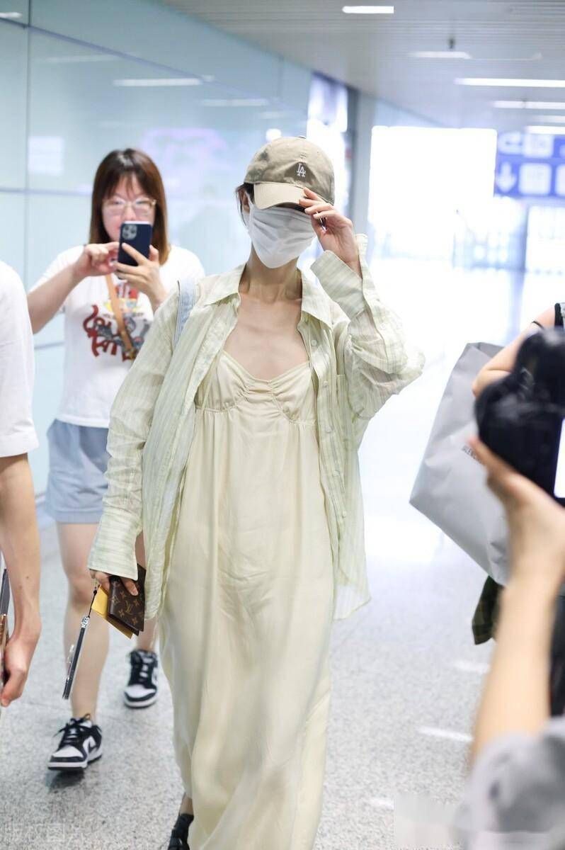 金晨现身北京机场,浅色连衣裙搭配棒球帽清新简约