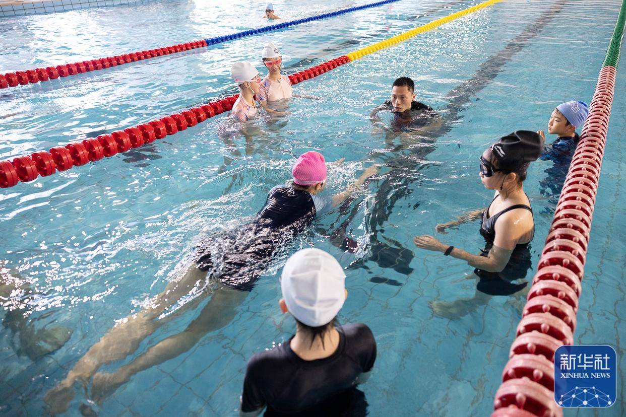 7月22日,教练员在浙江省湖州市游泳馆内指导小朋友换气动作.