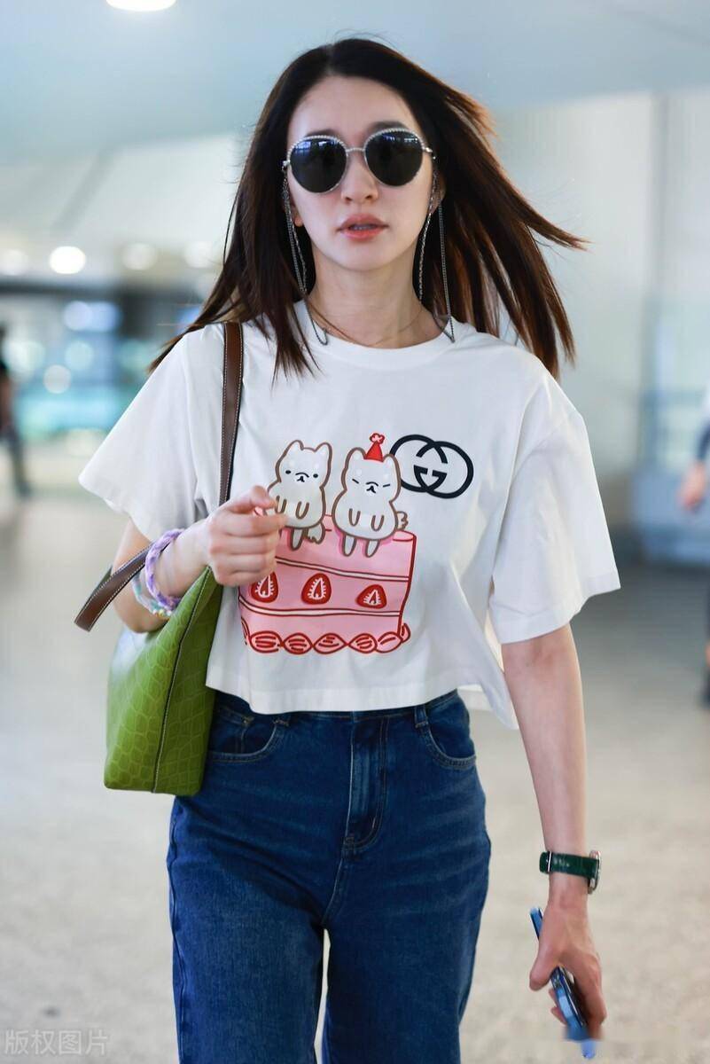 街拍:李小冉白色卡通印花t恤 牛仔裤 绿色腋下包可爱减龄_上海_机场