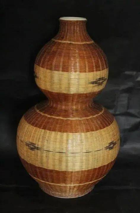 有一次,看到他工作室博古架上摆着一件竹编外壳,内装瓷瓶胆的花瓶,胖