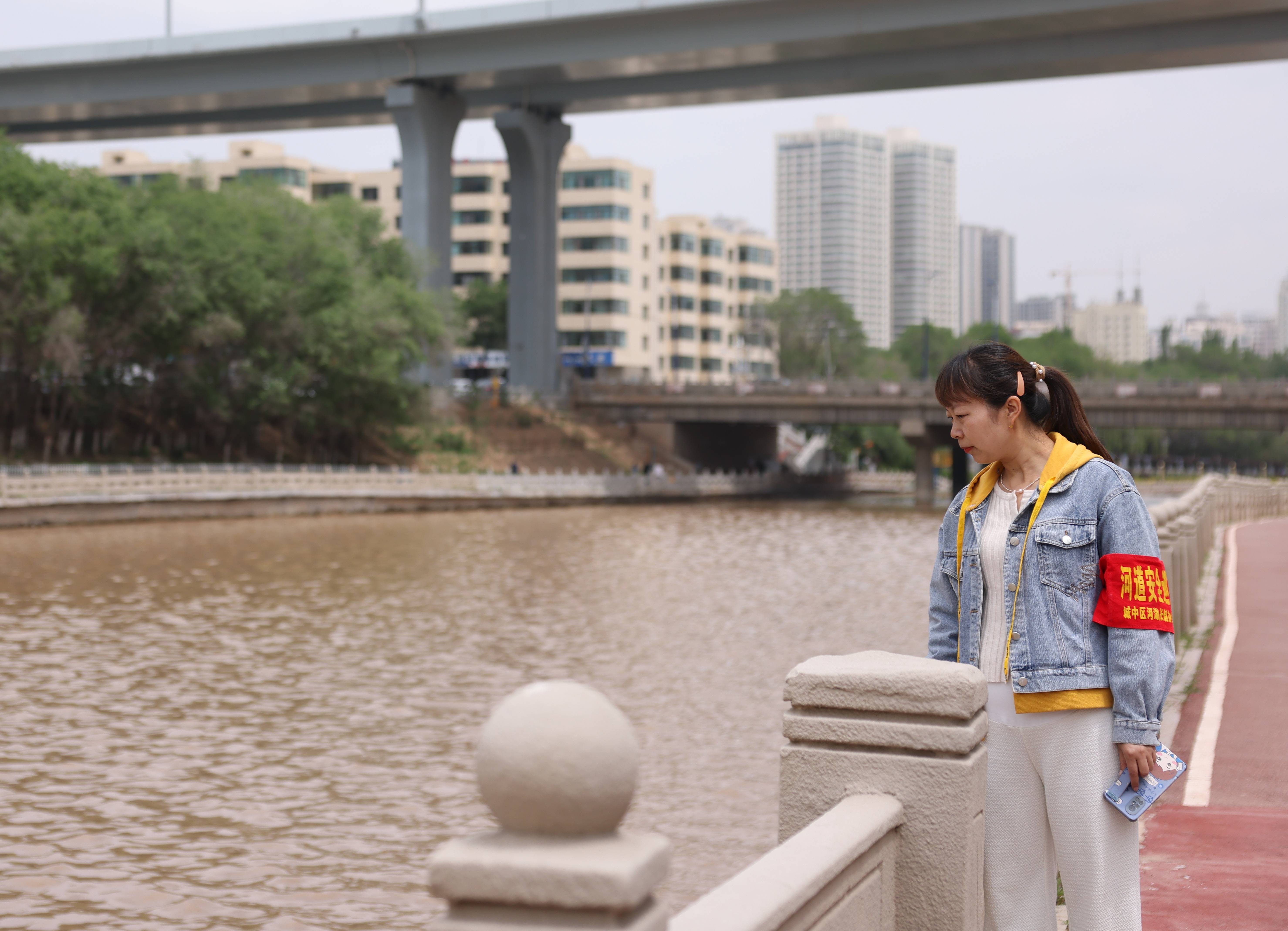 6月3日,在西宁市南川河沿岸,社区河长蒋晓芸正在巡河.