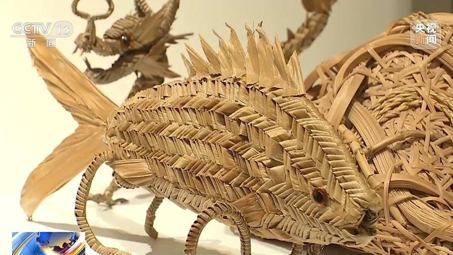 鲁诗雨来和王师傅学习棕编技艺,临走前,对放在展台上的棕编鱼爱不释手