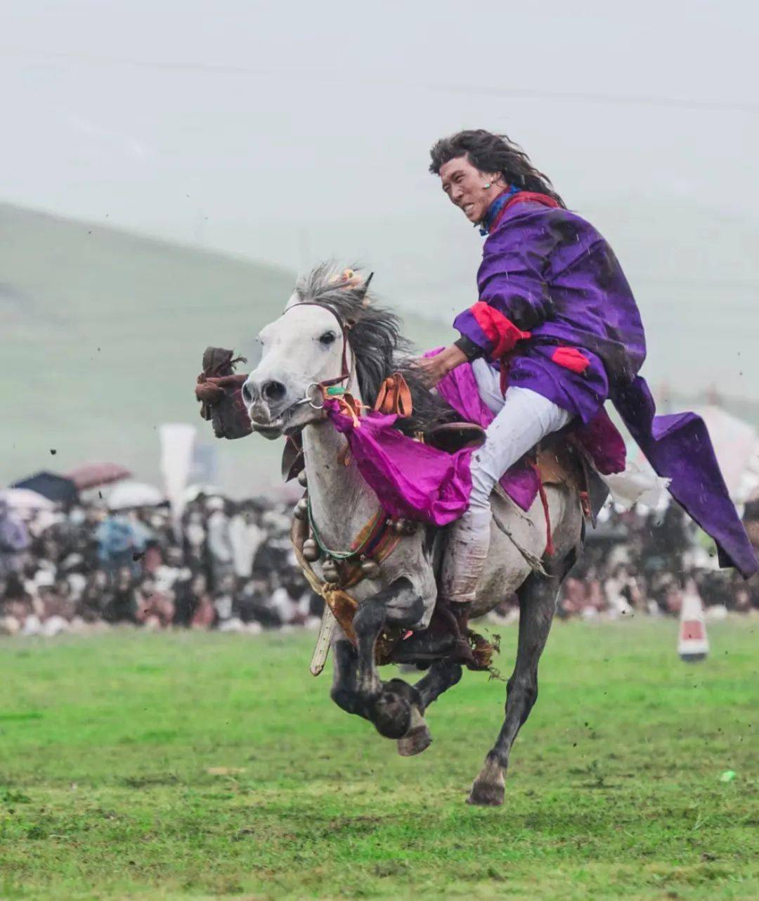 在骑马飞奔时俯身拾取地上的一条条哈达是检验骑手骑术的重要方式