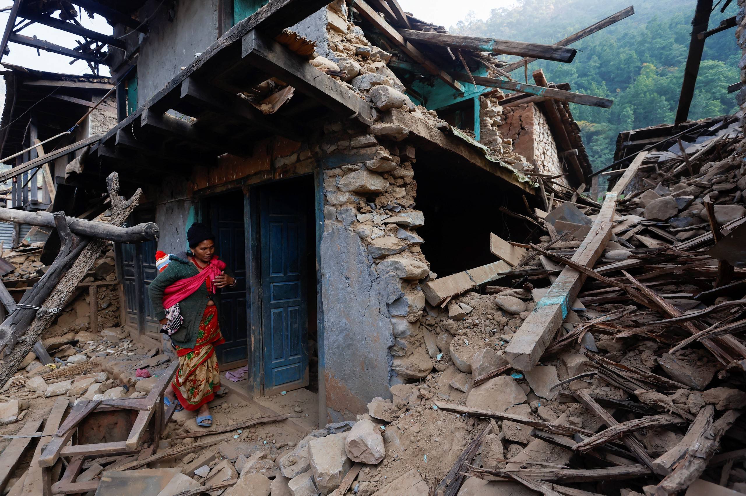 当地时间2023年11月6日,尼泊尔jajarkot,地震发生后,一名妇女带着孩子