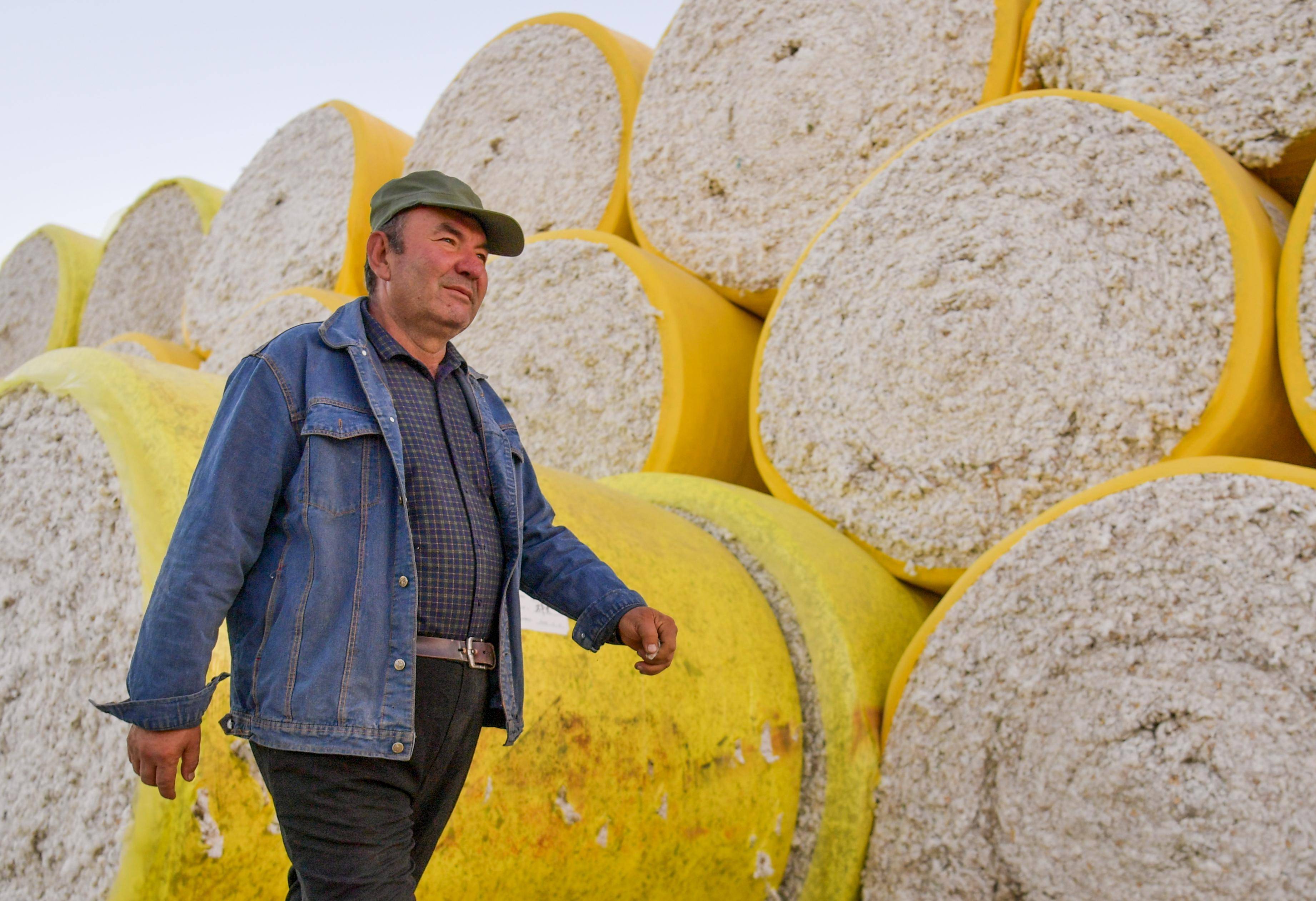 在新疆尉犁县一家棉花加工厂内,尔肯看着自家棉花摆放整齐后离开厂区