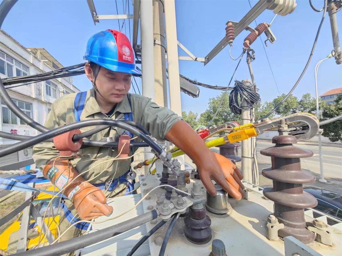 市江夏区供电公司工作人员,对变压器调档后的输出电压进行测量核实