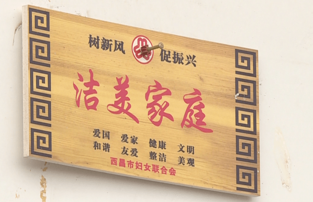 加洛加加家的院坝干净整洁,窗明几净,一块金底红字的"洁美家庭"牌子挂