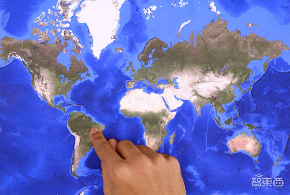 gemini猜测:一个人用右手食指指着世界地图上的巴西,因为该地图包括