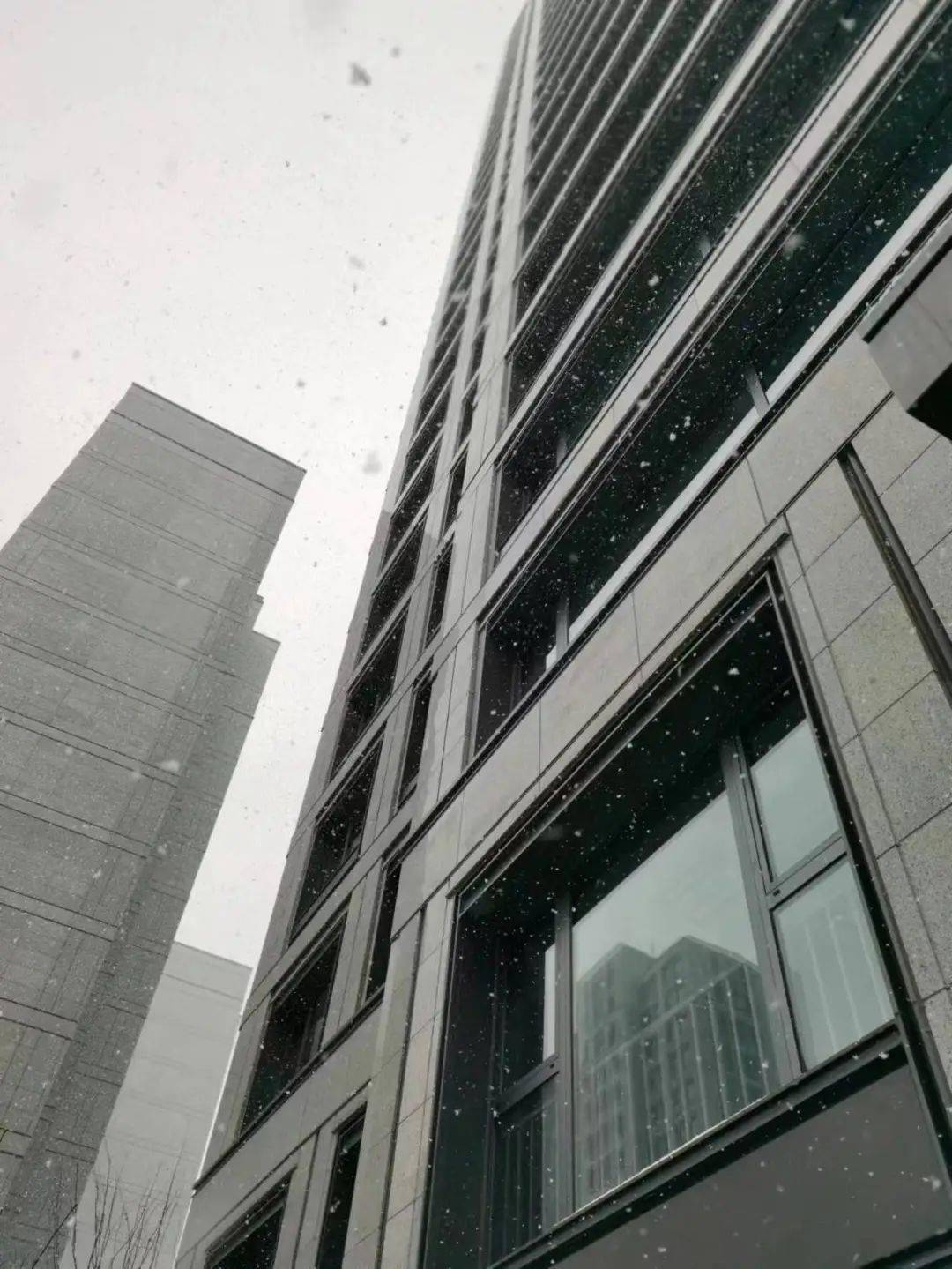 浅灰色石材嵌入大面积玻璃,周边窗框以线条勾勒,轻盈大气,在一众建筑